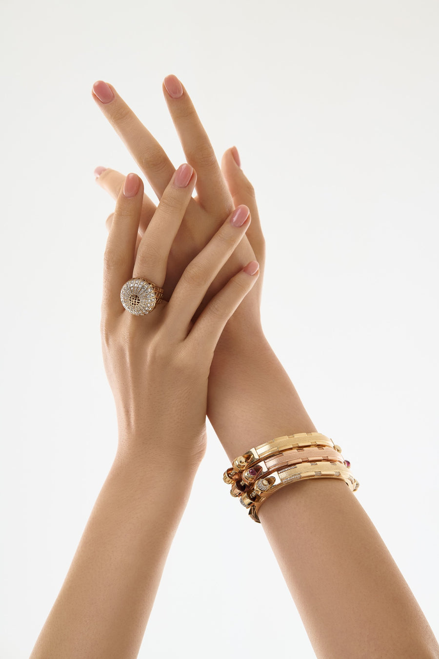 Gauhar Coupling Collection pavé diamond statement ring layered with rose and yellow gold sculptural bracelet stack.   