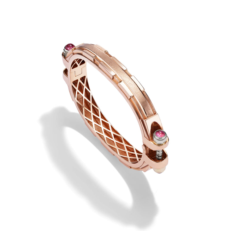 14k rose gold Coupling bracelet, angled view with pink sapphire cabochon bolt heads and warm gold lattice interior.   