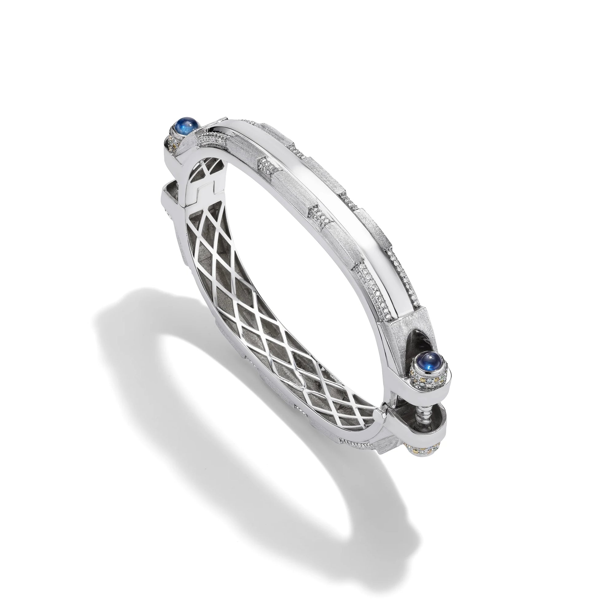 14k white gold Coupling bracelet, angled view with diamond pavé bolt heads, blue sapphire cabochon, white gold lattice.   